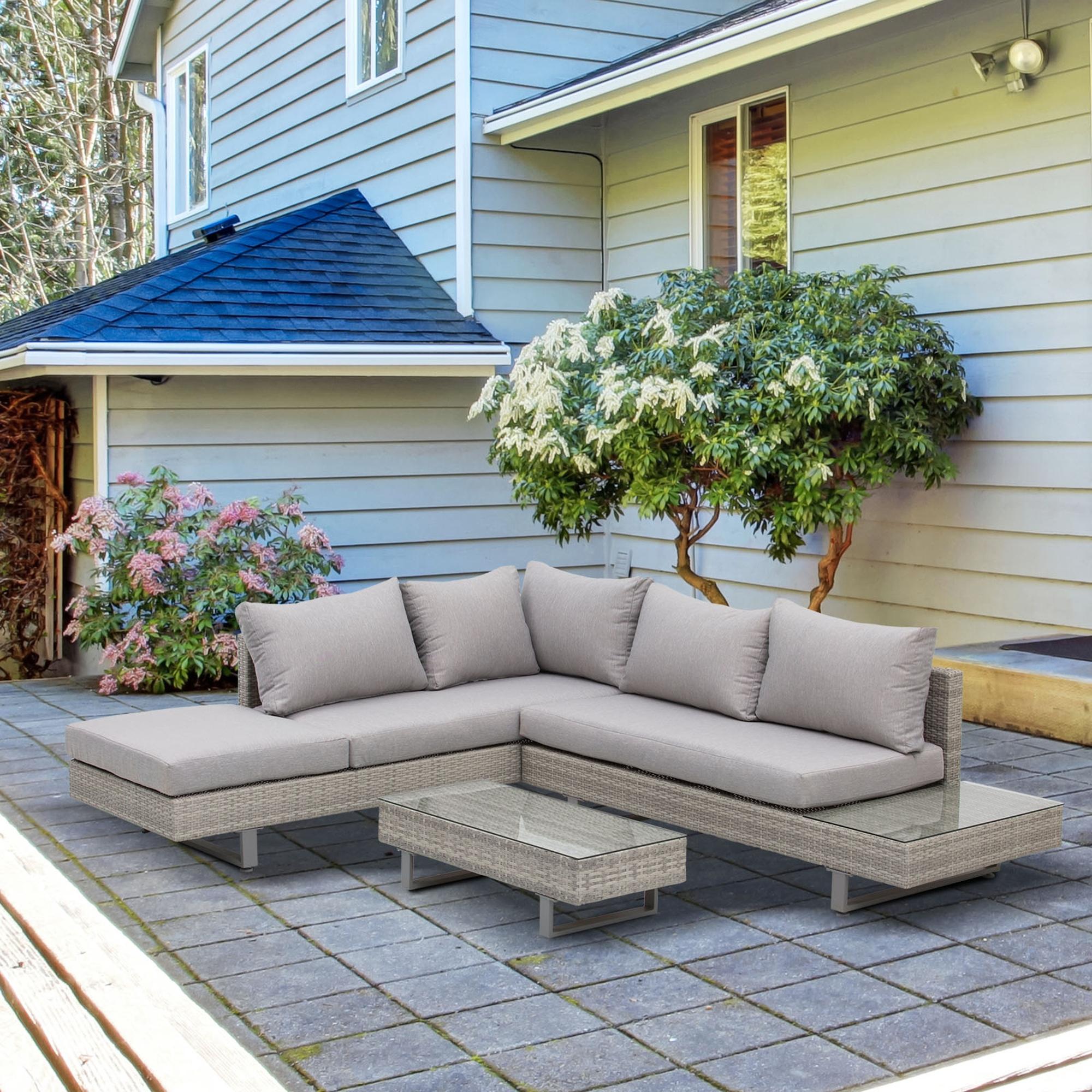 Salon de jardin d'angle gris clair installé sur une terrasse